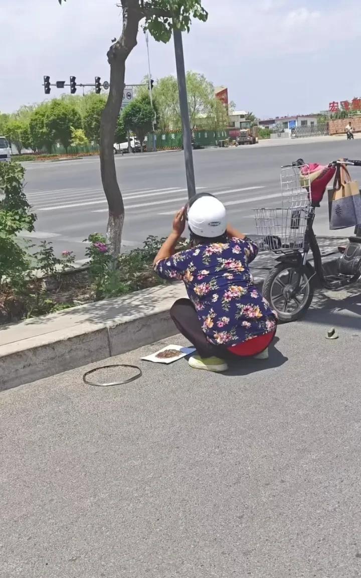 甘肃一大哥在路上看到一位大姐在马路上扔东西，大哥以为是瓜子皮、垃圾什么的，走过去