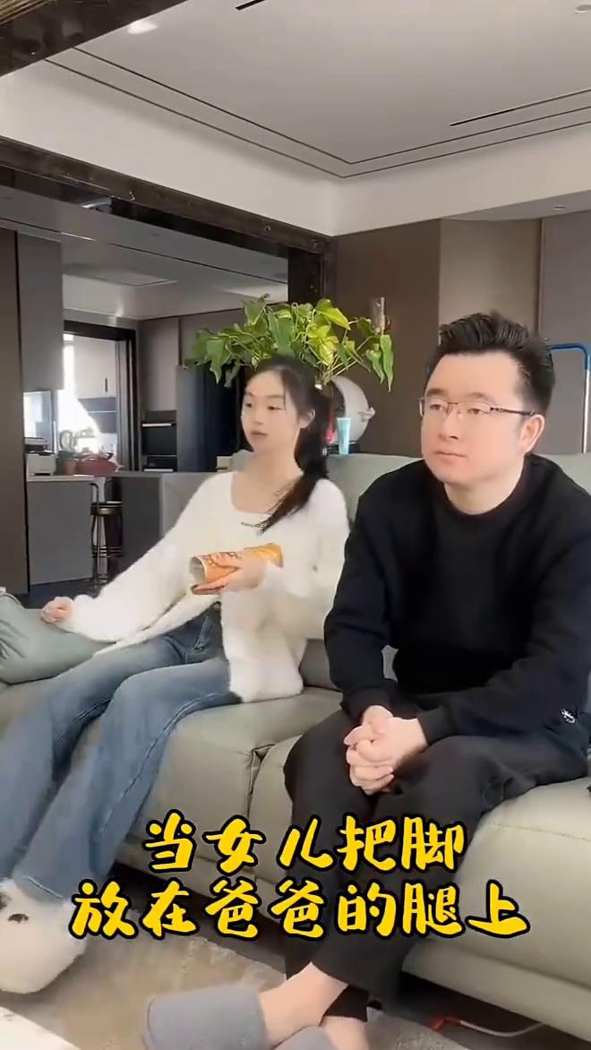 当女儿把脚放在爸爸的腿上，察觉到暖脚。
