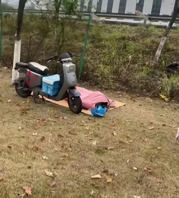 广东，有一名女子早上到河边跑步，发现有一名外卖小哥在空地上铺着垫子睡觉，旁边停放