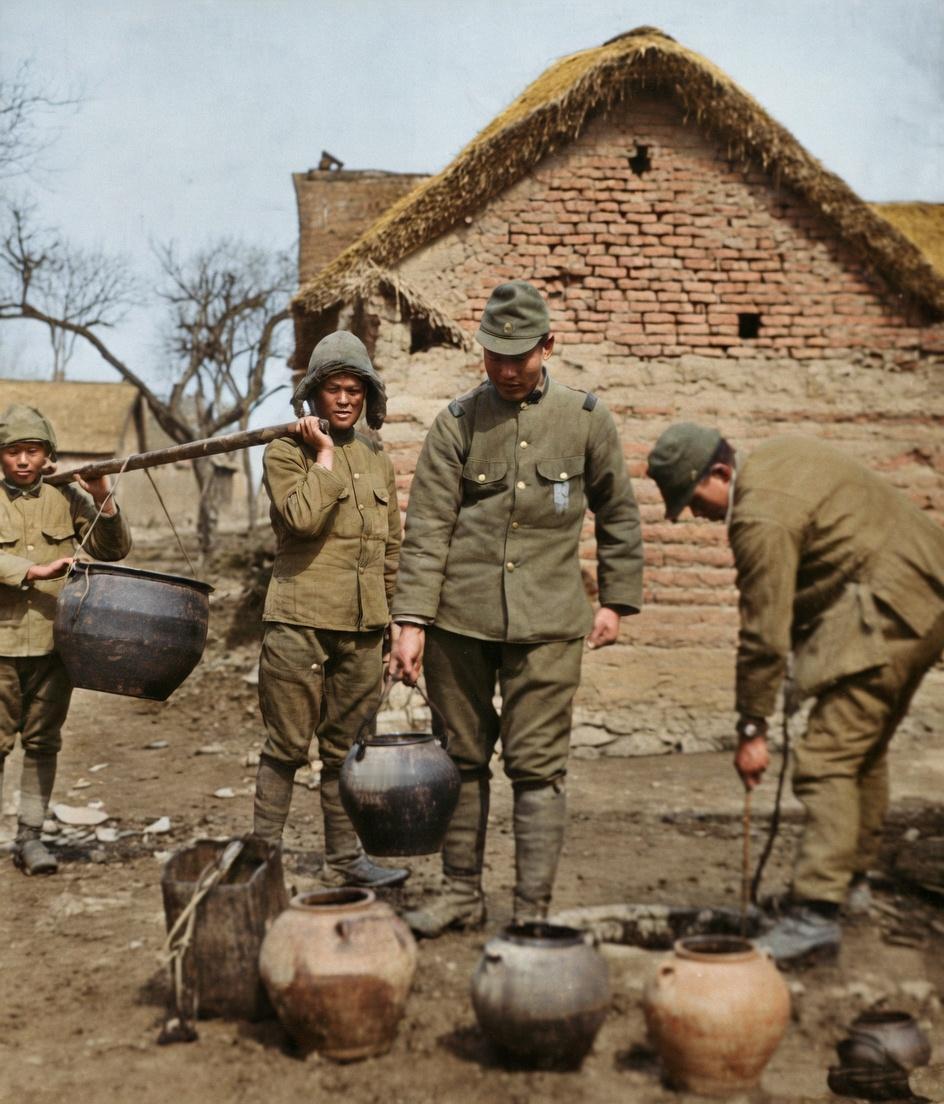 1938年3月7日，山东临沂汤头镇的农家院落，照片中左侧鬼子兵肩挑水桶、中间鬼子