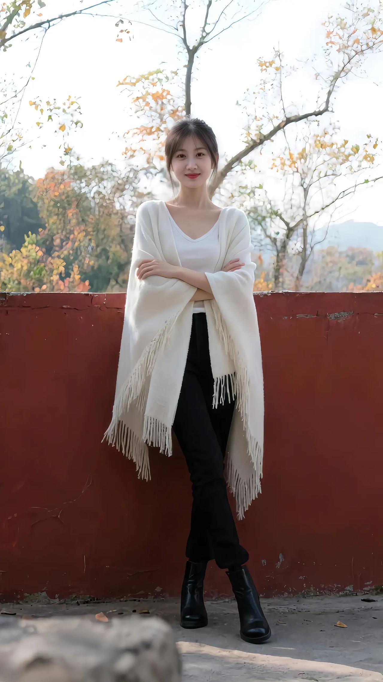 秋日暖阳下，白衣少女倚红墙，静享美好时光。