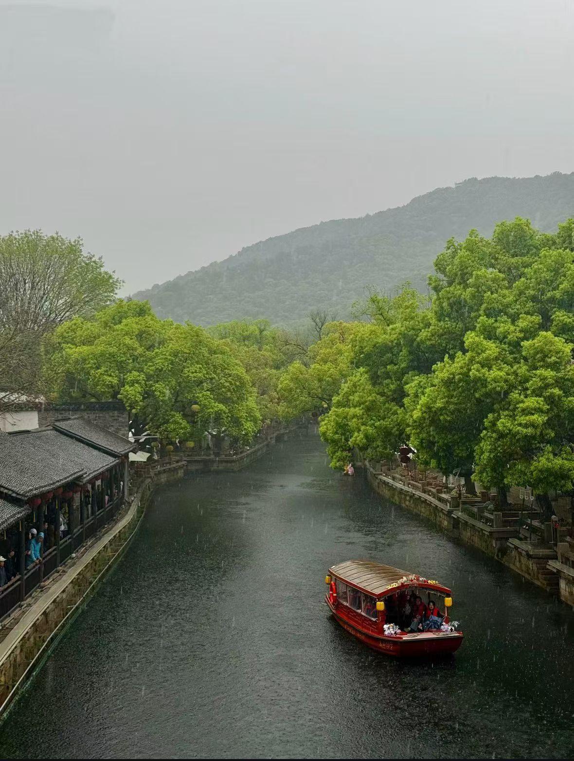小船在雨中缓缓驶过，景色真美。