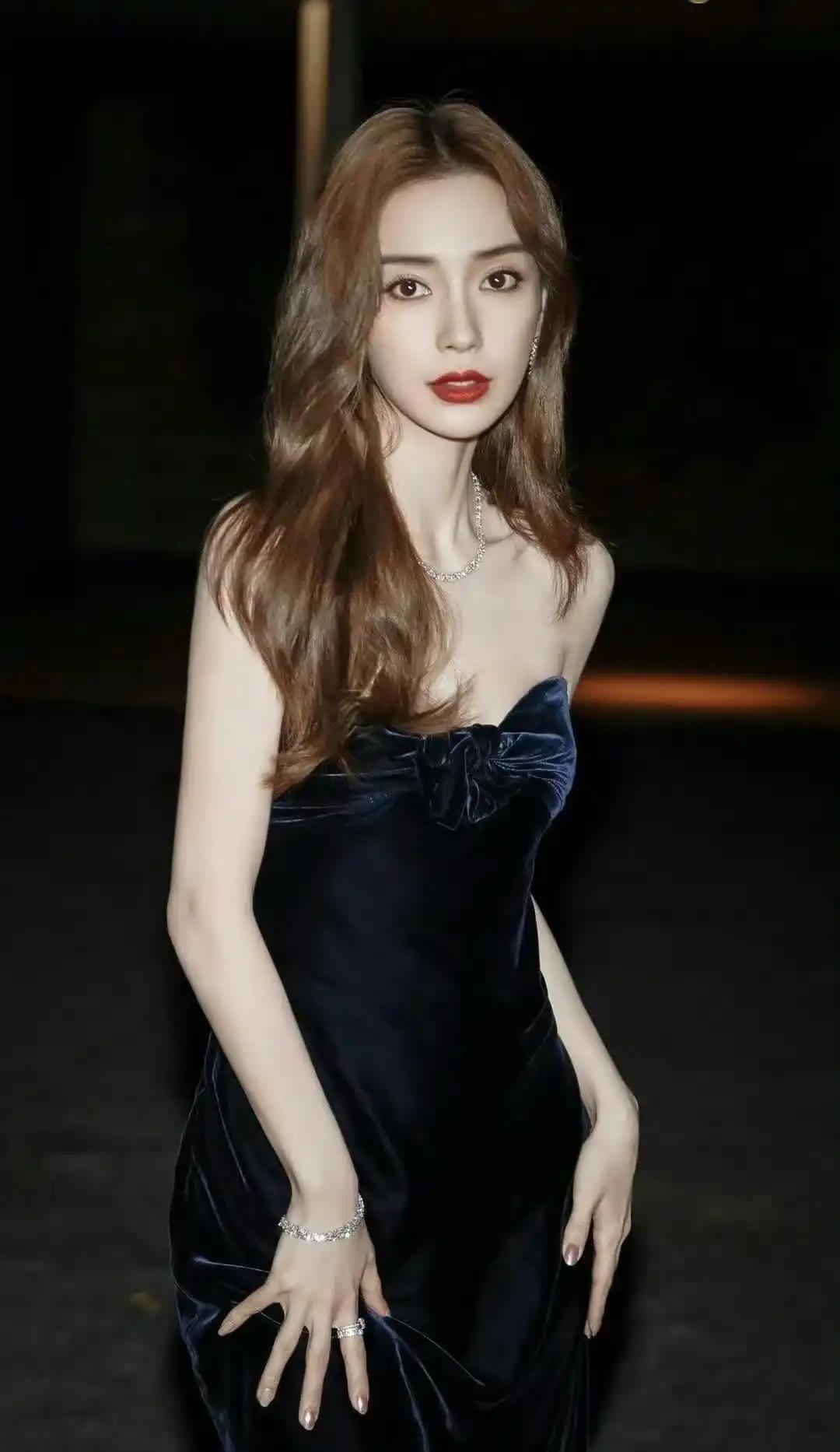 Angelababy身着深蓝丝绒礼服，红唇摇曳，举手投足间尽显优雅与神秘，美得让