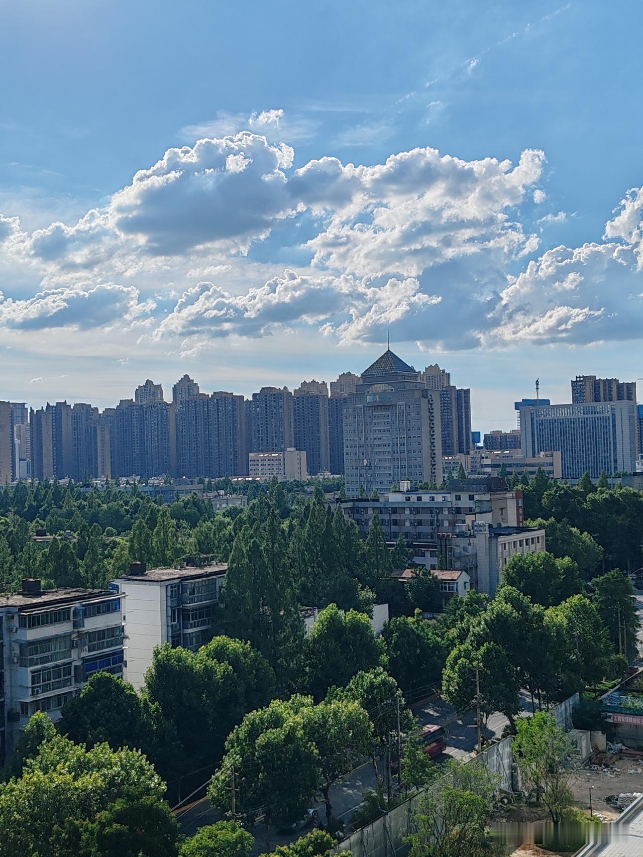 看今天武汉科技大学上空银色的云层在太阳的照射下显得格外壮观而美丽，而地面的大树被