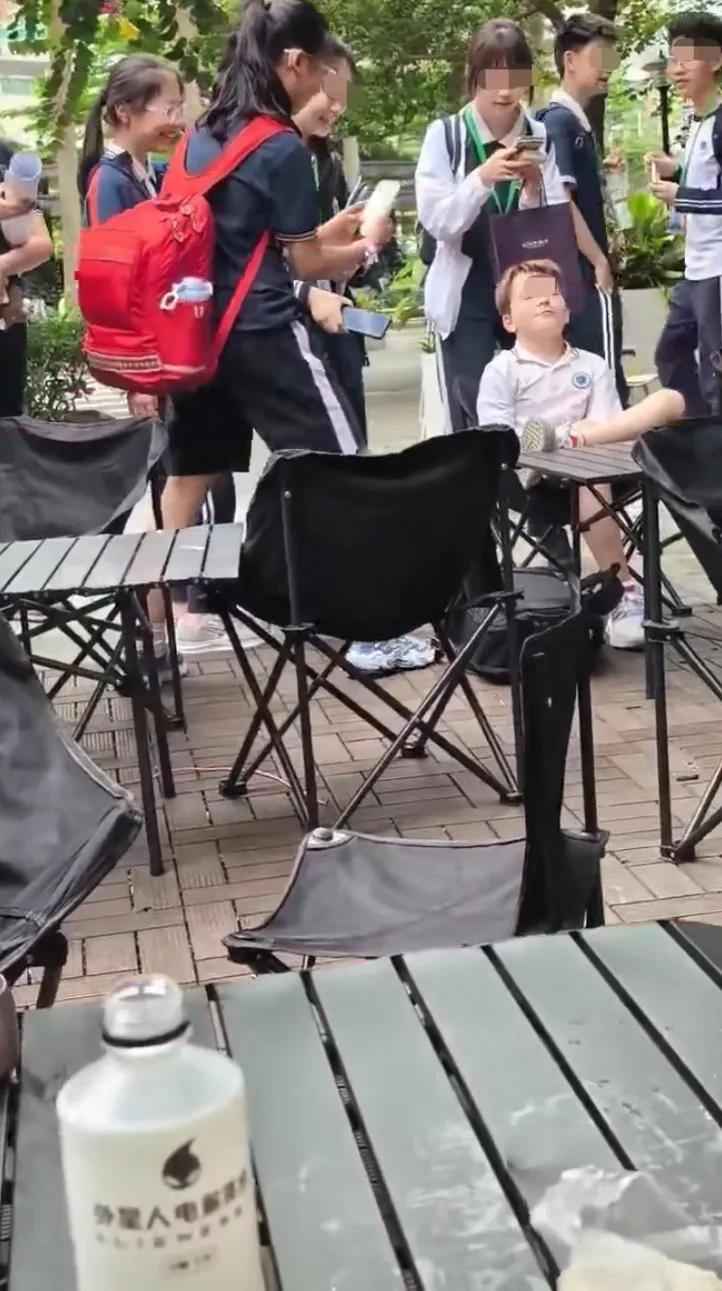 无语了，一群中国孩子，拿着手机贴着一个小老外拍摄，这算骚扰了吧，人家明显不乐意啊