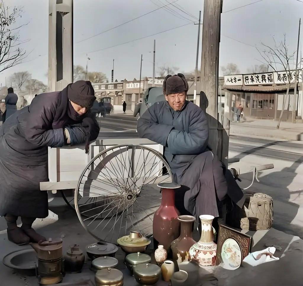 1933年冬，北京街头，一名卖古董的小贩在摆地摊。他坐在车辕上，双手插在袖管里。