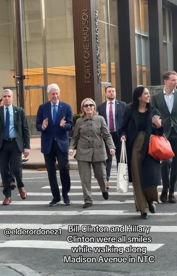克林顿、希拉里夫妇在纽约麦迪逊大道散步，身边一共有7名工作人员围绕，夫妇两全程面