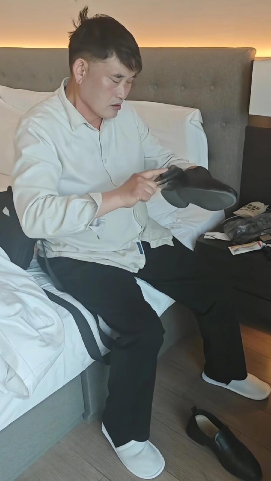 大衣哥太累了，在酒店里休息，侧着身就那么小眯一会，床旁边还坐着几个人，应该当地活