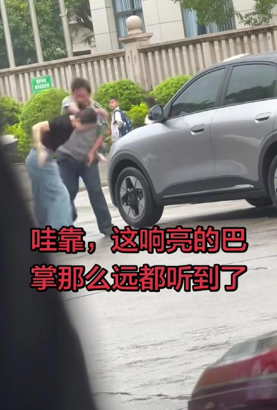 马路边的一幕:一名女司机因与保安发生口角，情绪失控后上前轻轻踹了保安一脚，保安随