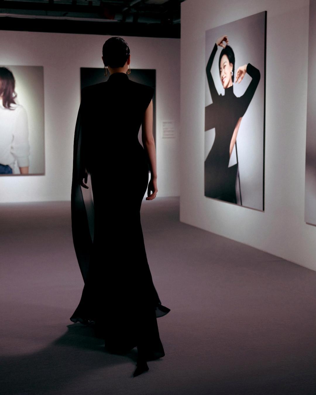 倪妮身处艺术画廊，一身黑色透视长裙游走在巨幅海报之间，完美诠释了**“与艺术共生