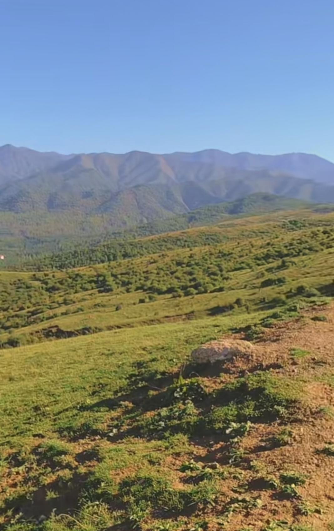 山峦起伏，绿意盎然，大自然的壮丽画卷。山里的天空和大地容为一体，那是一种难以言喻