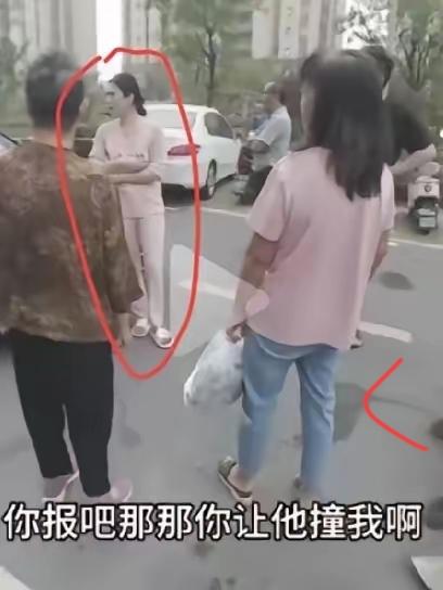 就是这个粉衣女子，组织人拦婚车，给了三条烟和红包还嫌不够，扬言报警也没用。这是典