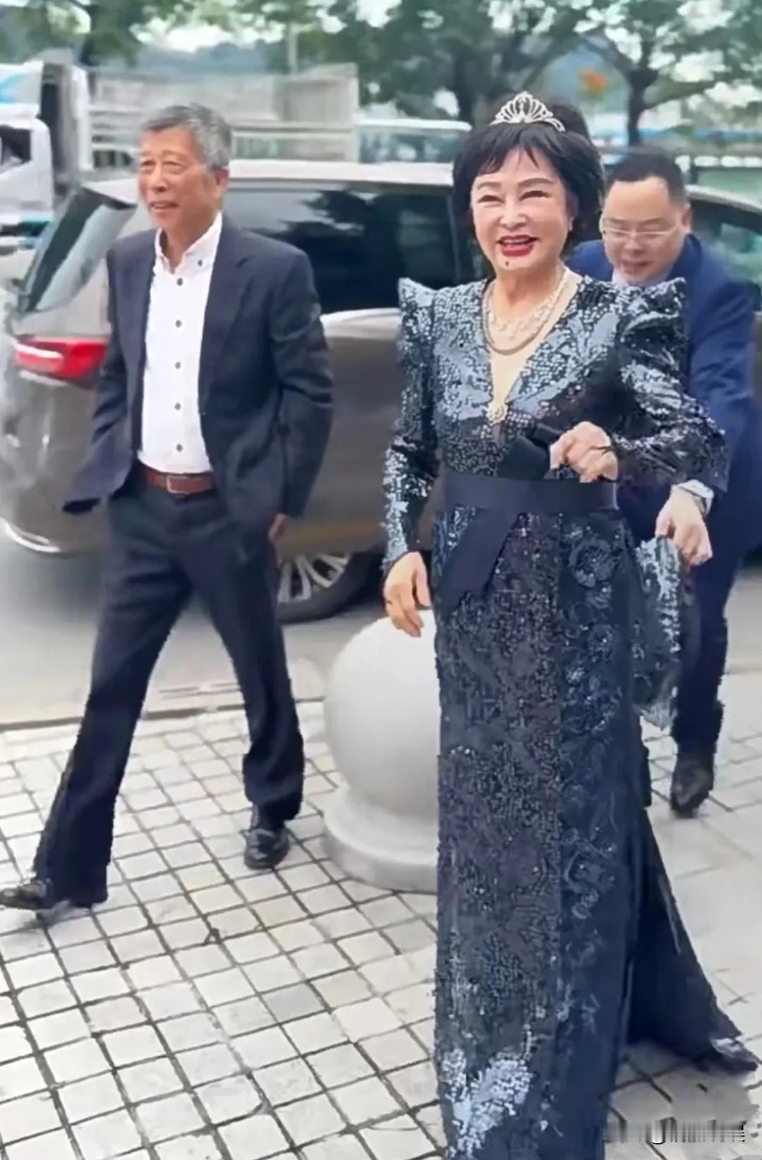 75岁的著名歌唱家朱明瑛老师出席活动，她头发浓密，身材微微发福，笑容满面，步伐轻