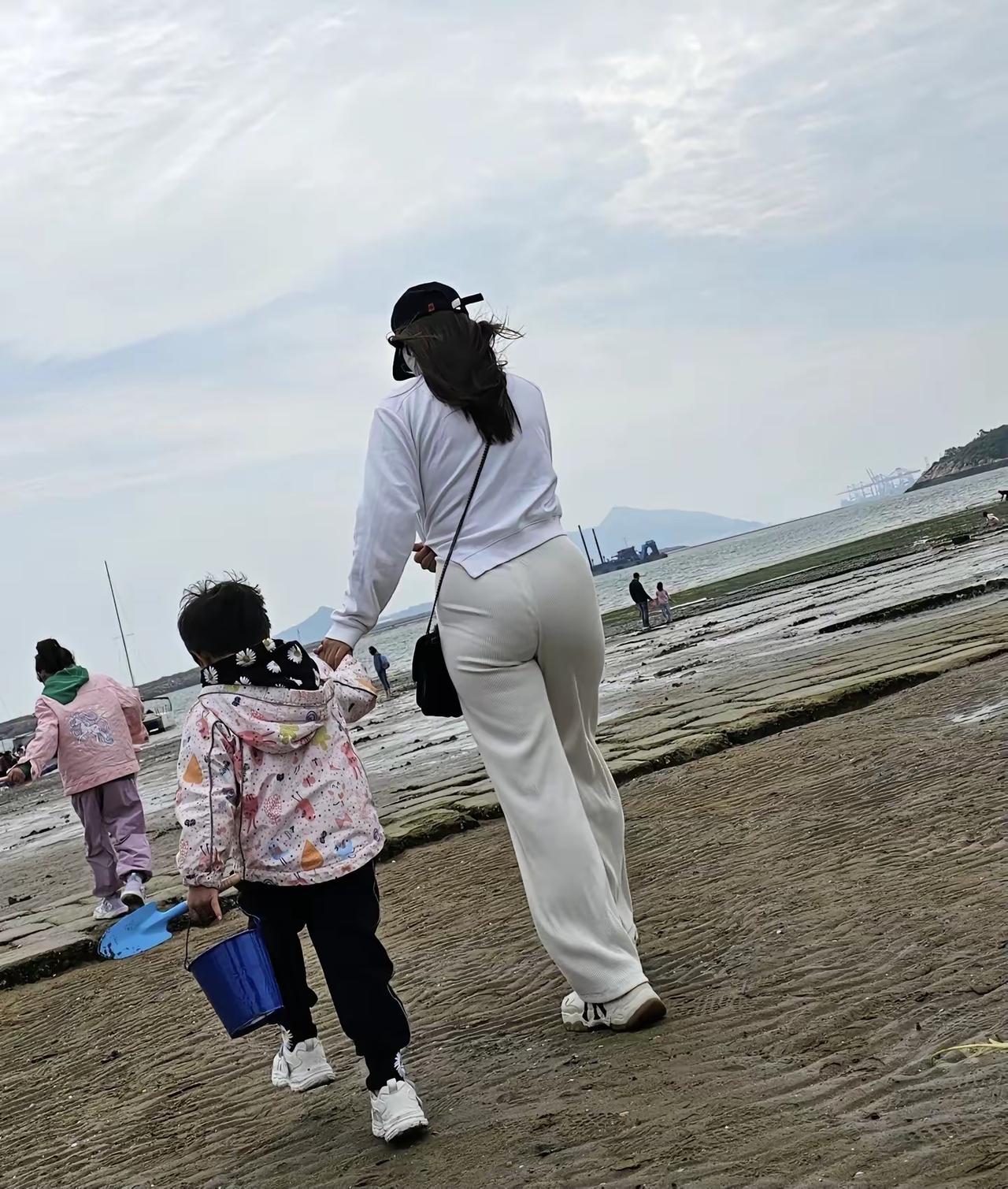 海边溜娃的少妇。