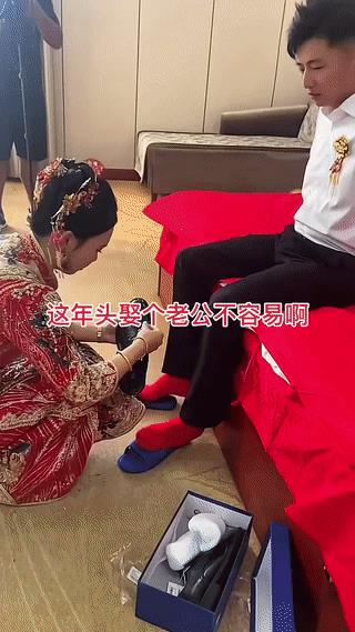 新娘子亲自为入赘她家的新郎穿鞋穿袜。看起来真是非常的细心。虽然新郎是“上门女