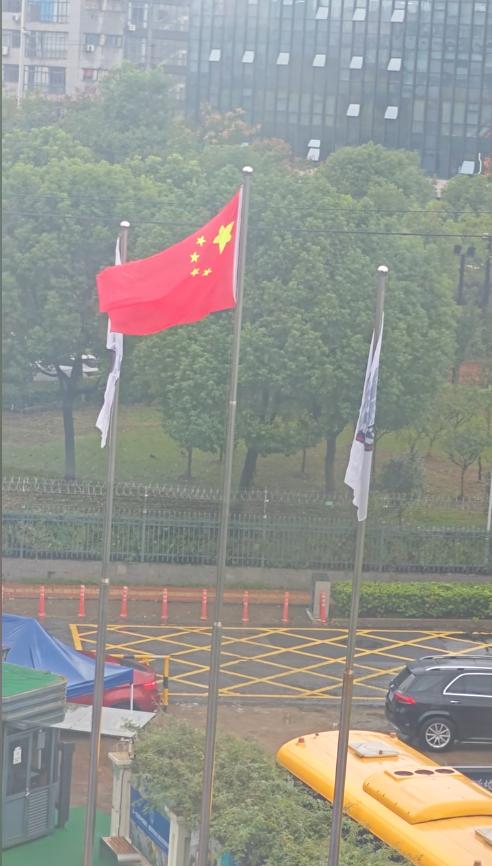 “破防了！”下雨天，三面旗子都被淋湿了，垂在那里一动不动。女子站在自家窗户前，看