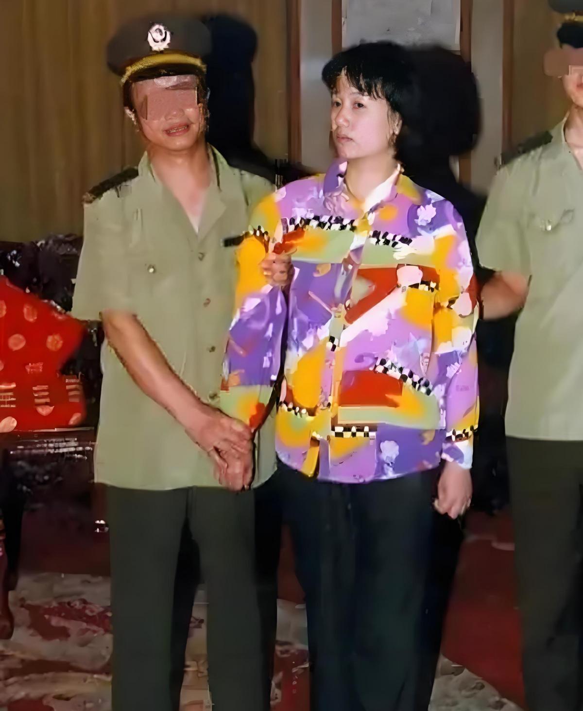 2000年，刘艺霞被判死刑，照片中的她，身穿花衬衫，被两名警察押送着，面无表情，