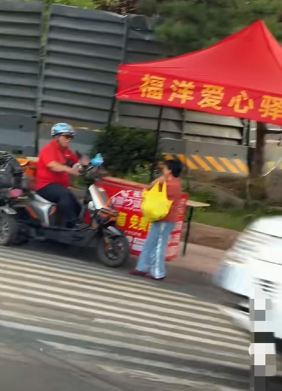 爱心驿站旁的一幕，大妈从冰柜里面装了满满一个塑料袋的饮料，转身提溜着就想走，路过