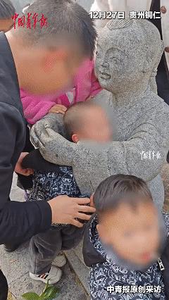 铜仁公园3岁娃把脑袋塞进童子石像胳膊缝，卡得死死的，嗓子哭到劈叉。宝妈急得团团