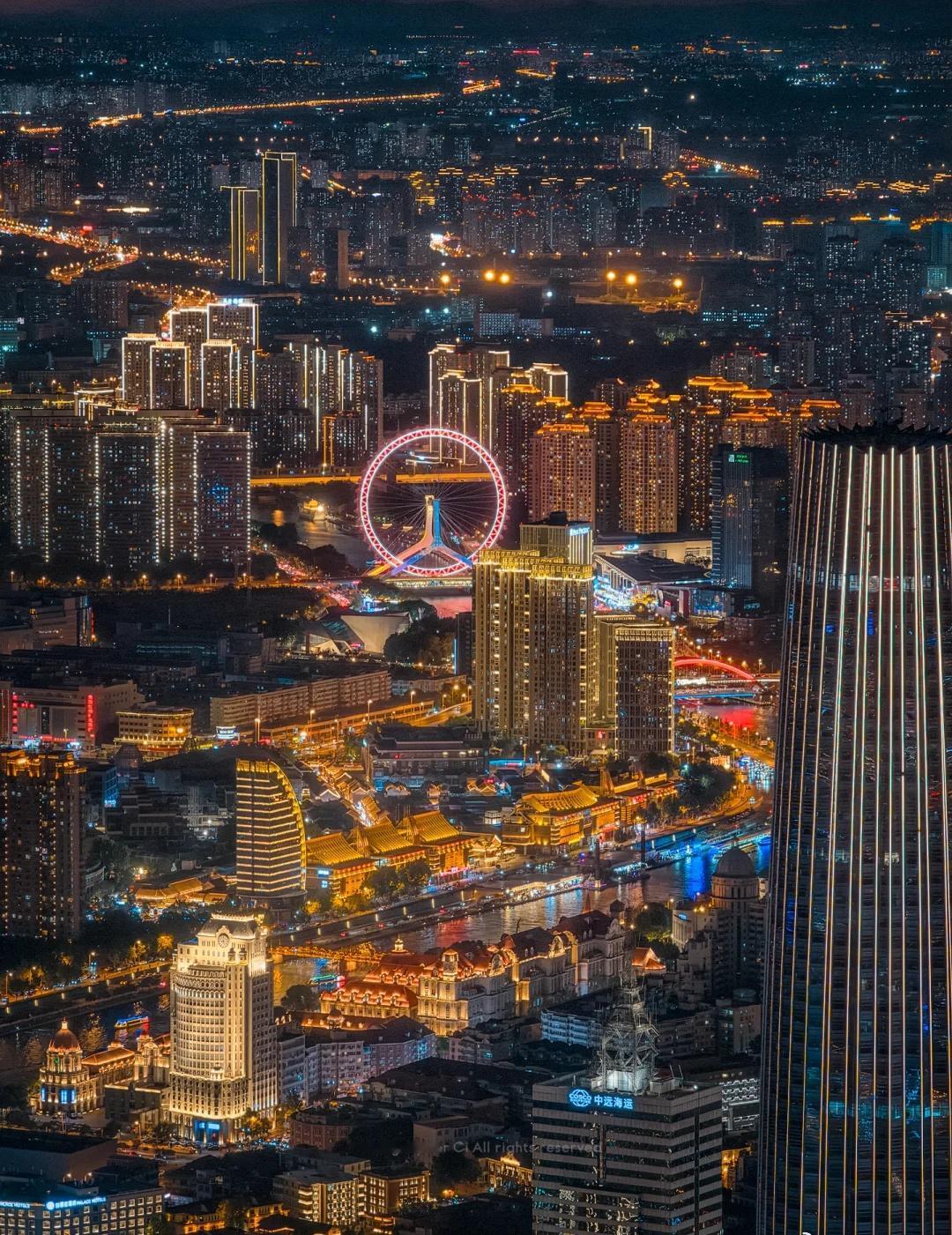 长焦镜头里，海河像一条缀满碎钻的丝带，从城市心脏穿流而过——两岸的霓虹在高空视角