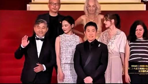 辛芷蕾站在C位，正在接受红毯拍照。后面的嘉宾伸手把她往后一拨，梁朝伟被请到了中间
