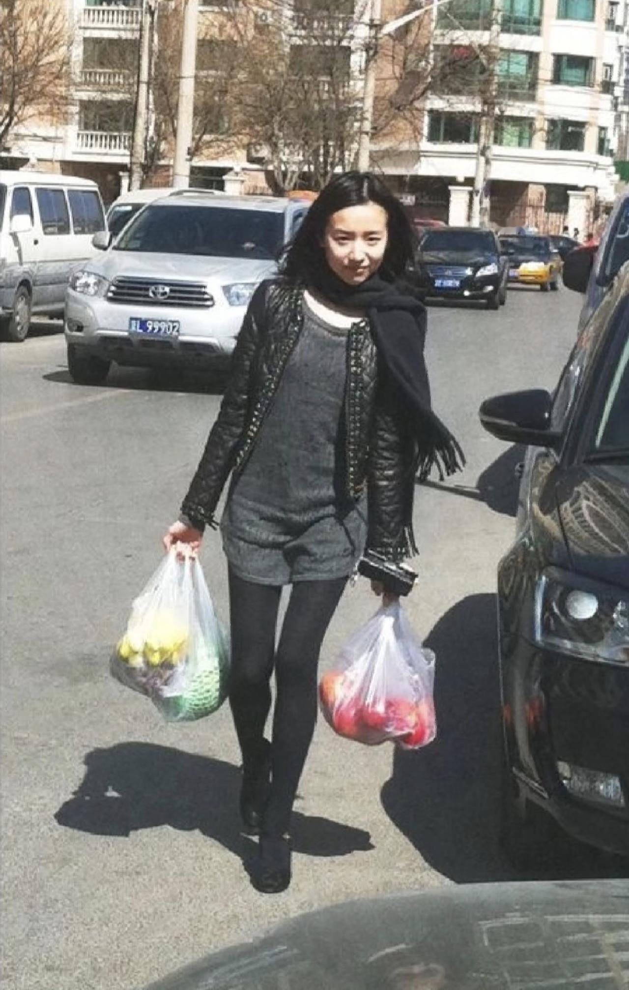 2011年，董洁两手提着水果，走在老式小区的路上，脸上带着淡淡的微笑。那时，