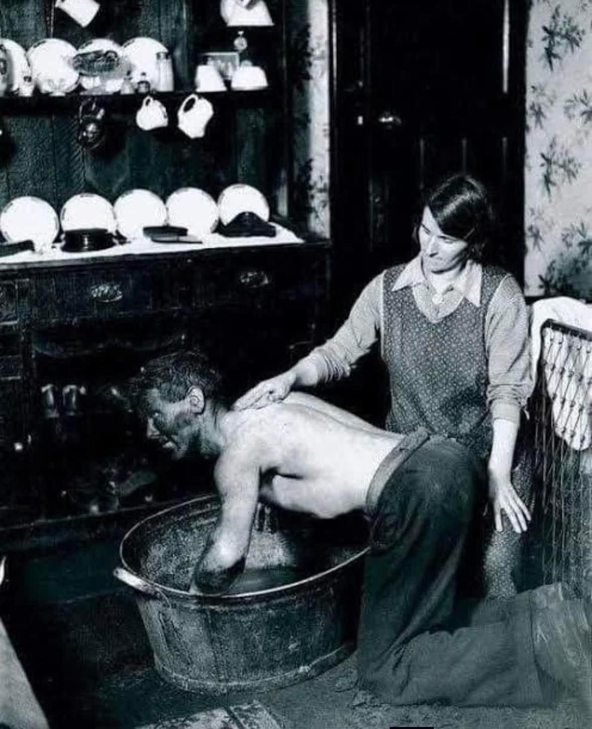 1931年，一位威尔士矿工的妻子在自家厨房里，用一个锡盆为刚下班的丈夫洗去身上厚