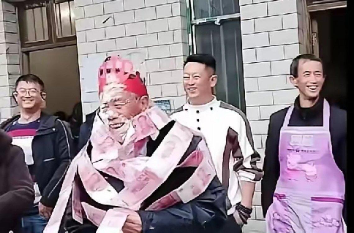 寿宴变成了戏台，老人被套上层层现金“枷锁”，脸被蛋糕涂抹模糊。他在镜头前挤出笑容