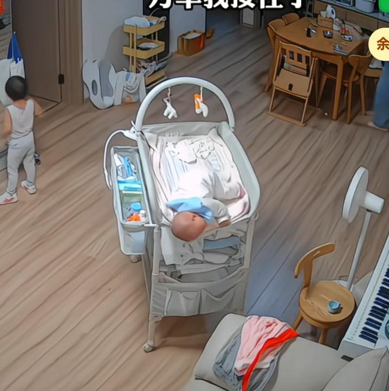 妈妈去厨房热饭，宝宝在婴儿床上差点一头摔下来，幸亏妈妈眼疾手快跑过来，一把抱住，