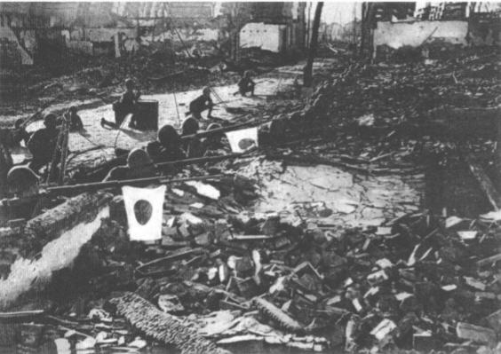这是1937年淞沪会战的一幕，被鬼子轰炸后的住宅区变成了一片废墟，鬼子趴在废墟上