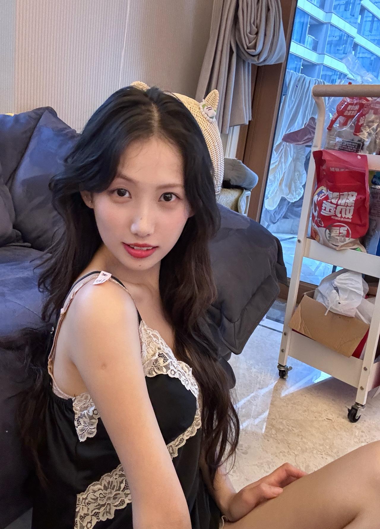 这女生坐在沙发上，穿着睡衣，好可爱。