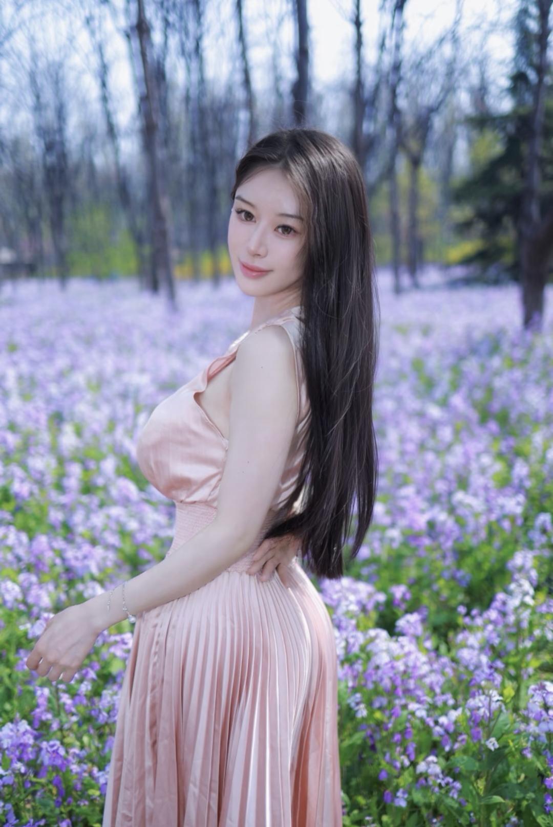 穿搭上，她身着浅粉色缎面连衣裙，收腰+百褶设计凸显温柔曲线，自带柔光质感，和二月