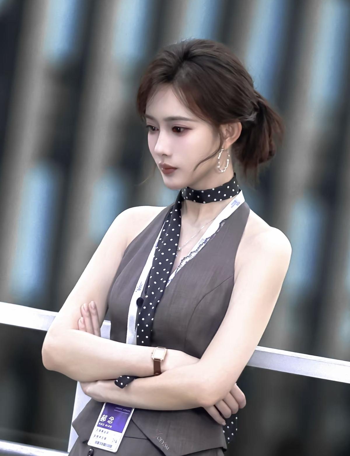 李一桐这套职场路透太绝了，灰调挂脖马甲搭配波点丝巾，清冷又干练，妥妥的都市精英姐