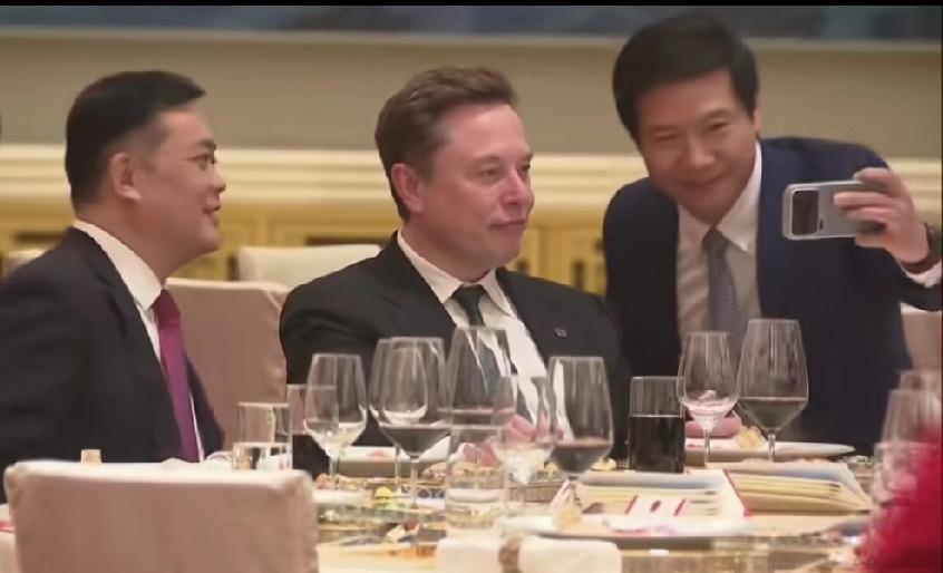 雷军找马斯克合影，马斯克坐着雷军弯腰配合他，很多人以为马斯克看不起雷军，所以一副