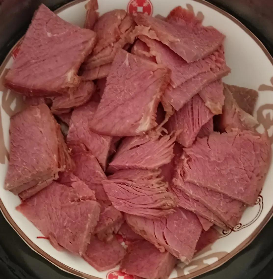 售货员正在给我切刚出锅的卤牛肉，一个小女孩，大约有五六岁的样子，个子才刚刚有柜台