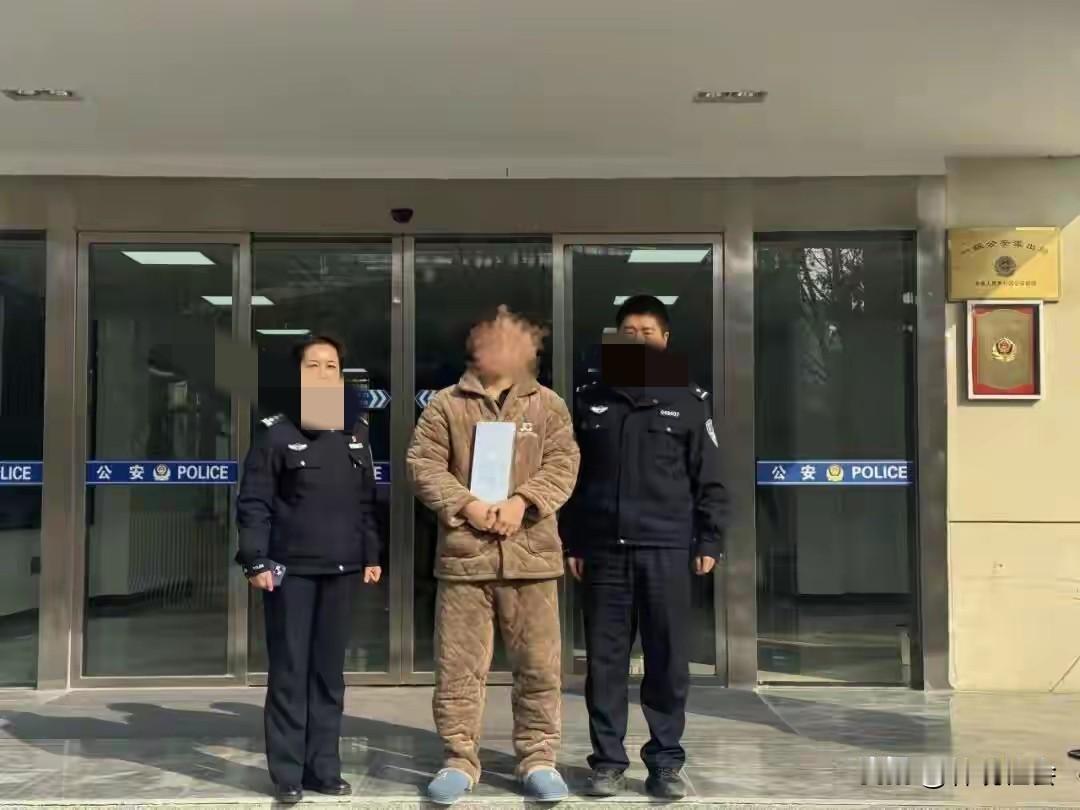 一名男子双手抱着一块银板，身上穿着棉睡衣，脚上穿着棉拖鞋，左右两边一边一名人民警