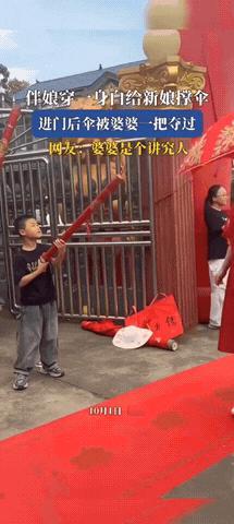 湖南一女子结婚，穿了红裙子，伴娘穿了一身白裙帮新娘撑伞，原本是喜庆的事，可快进门