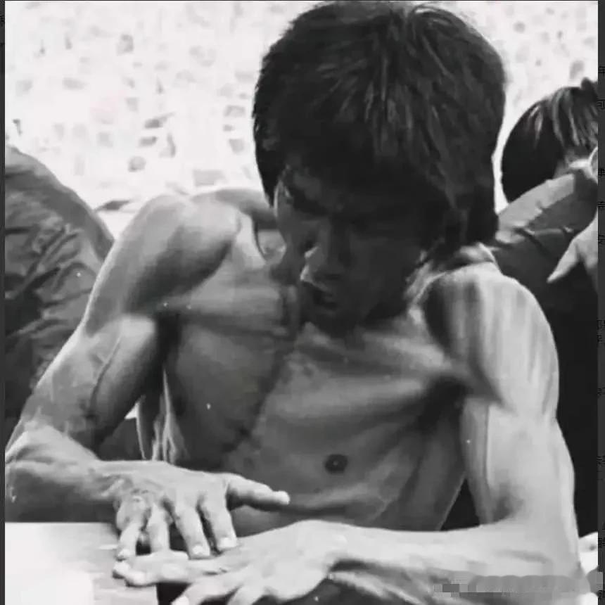 1973年，李小龙正在拍摄电影，留下的一张剧照。照片中，李小龙正在做着导演安排