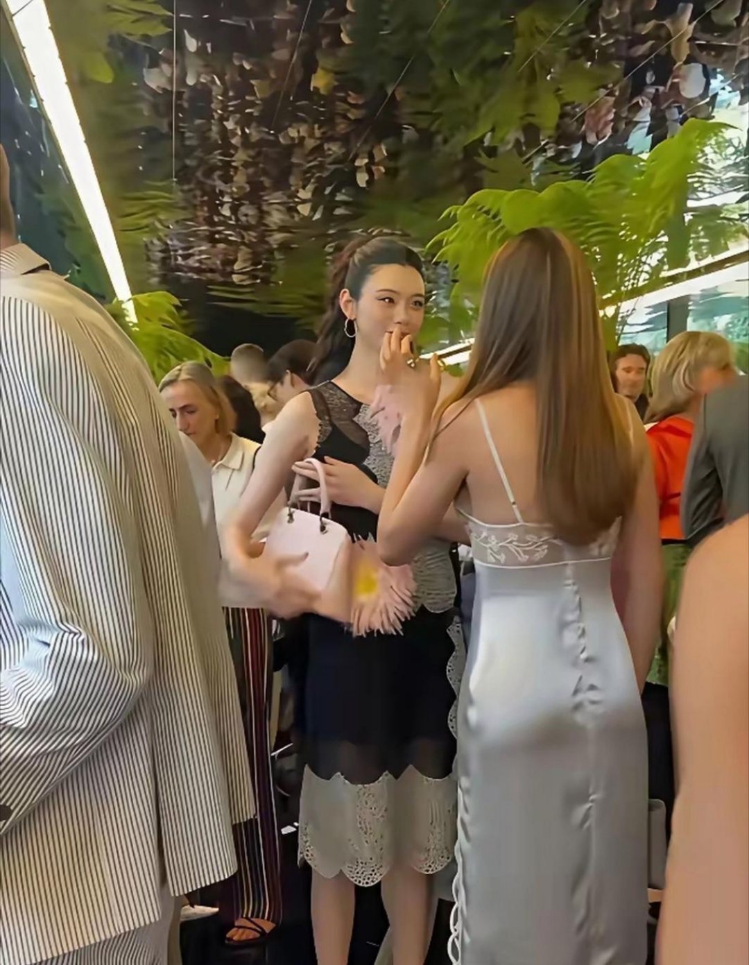 奚梦瑶和谷爱凌聊天，瞥见镜头立刻拎起包包，商标对准镜头，反应速度绝了。​