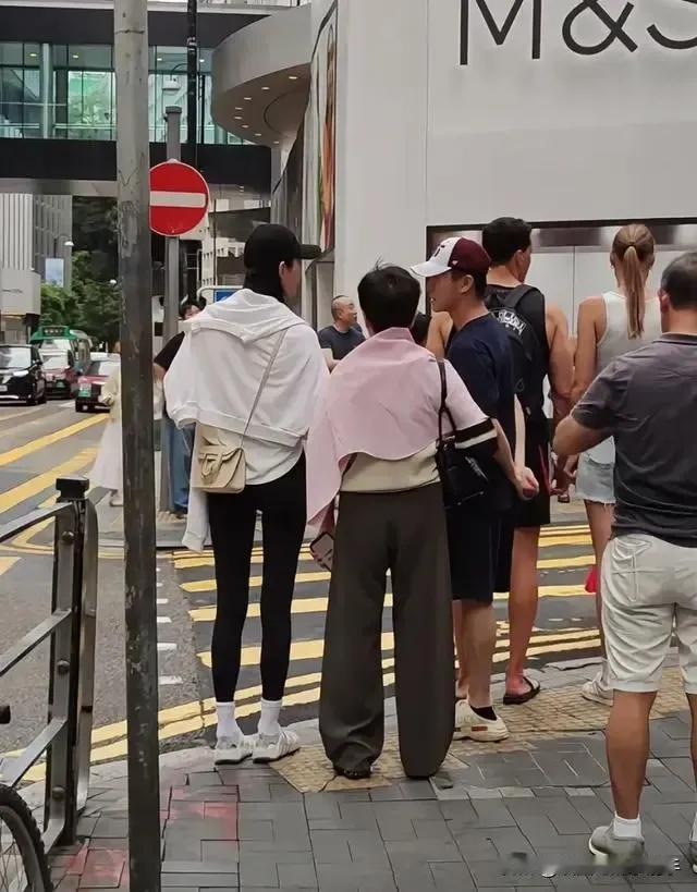 近日在香港中环街头，赌王四太梁安琪与儿子何猷君、儿媳奚梦瑶一同出行的画面引发关注