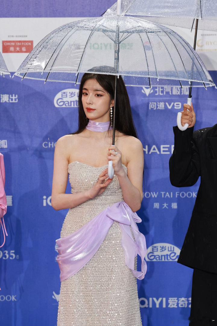 钟丽丽被雨淋了她用手挡雨的那一瞬间被拍下来了。不是摆拍，是真的在挡雨。但那个画