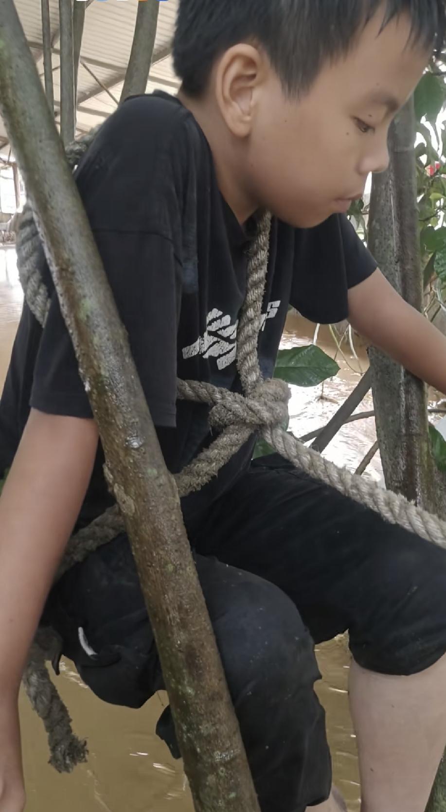 孩子被绑在了树上，发生了什么情况呢？原来，当天孩子和父亲遇到了洪水猛涨，两个人没