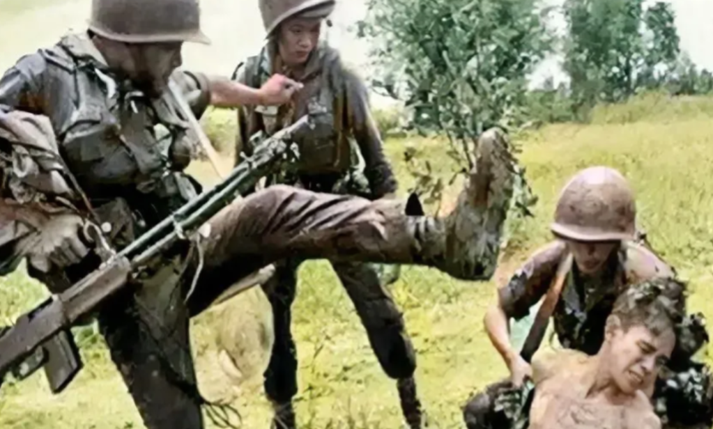 60年代，越南战争期间，几名韩国士兵围在一起，正在“惩罚”被俘的越南士兵，从照片