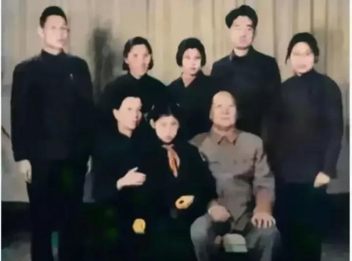 在一张有些泛黄的老照片里，毛主席和家人围坐相聚。李讷乖巧地坐在毛主席身旁，脸上满