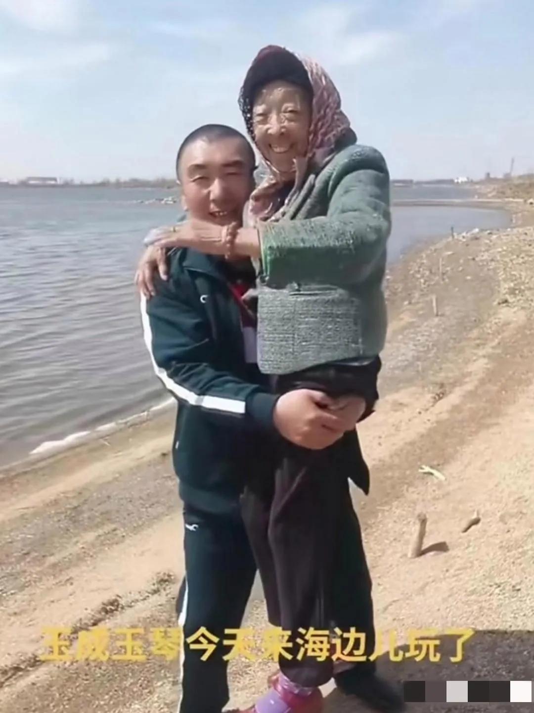 李玉成带年长自己30多岁的妻子马玉琴来海边游玩：被李玉成抱在怀里的老婆满脸皱纹，