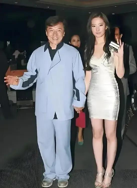 成龙大哥笑意盈盈，还紧紧拉着一位大美女的手！满屏的大长腿，皮肤白到发光，这画面