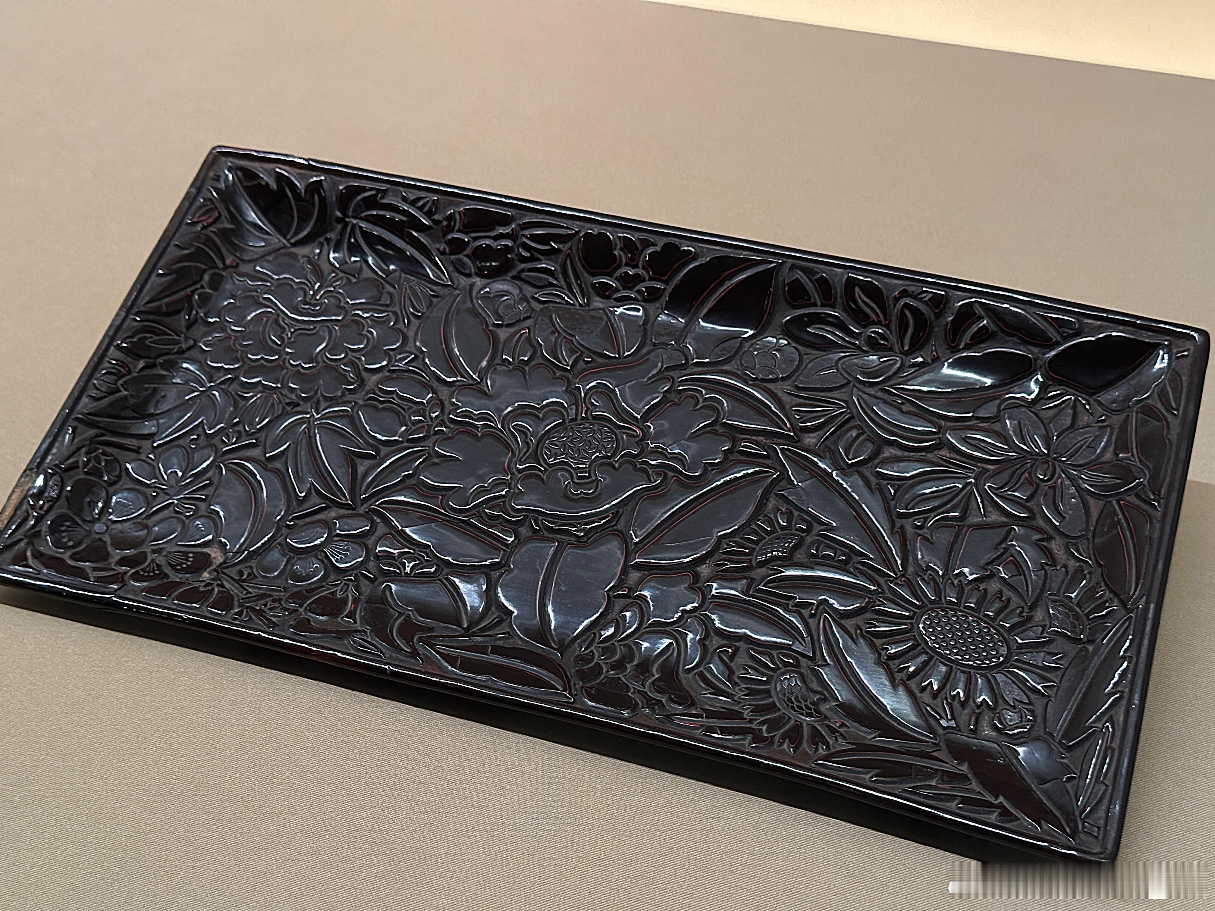 剔黑花卉纹长盘南宋13世纪东京国立博物馆藏漆层较薄，漆面平坦。黄漆地上黑、朱