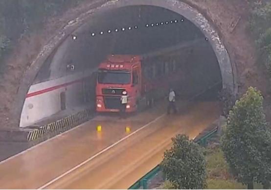 罚200元记9分轻不轻？货车司机把车停在高速隧道口盖雨布，民警急得隔着车流大喊。