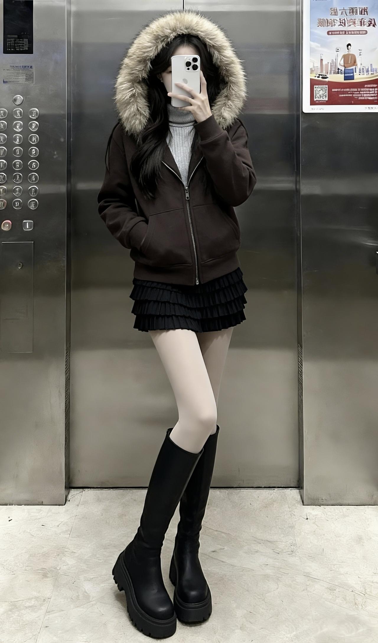 深棕毛绒领连帽外套裹满暖意，内搭灰高领+黑百褶裙，光腿神器+厚底黑靴把酷飒和温柔