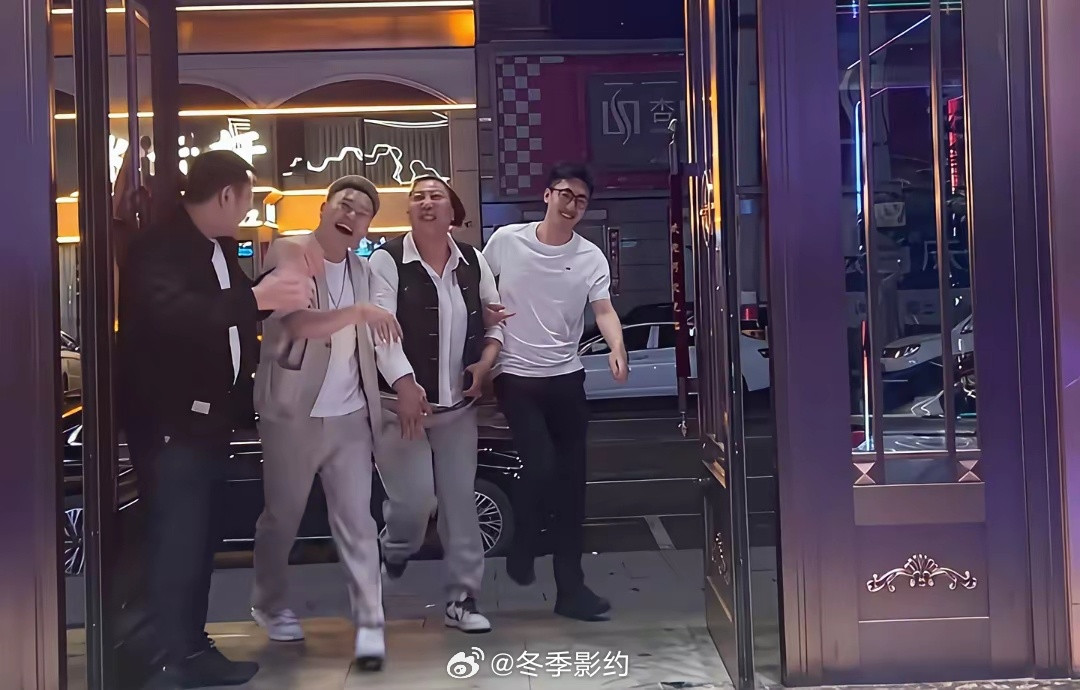 东北雨姐与友人聚餐结束后从酒店大门出来时的一幕，身旁一左一右两边有小鲜肉搀扶，一